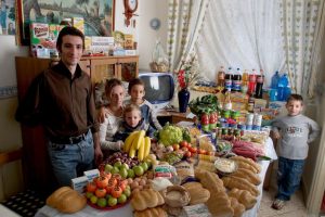 ITA03.0001.xxf1rw (MODEL RELEASED IMAGE) In the kitchen of their apartment in Palermo, Sicily, Italy, the Manzo family—Giuseppe, 31, Piera Marretta, 30, and their sons (left to right) Mauritio, 2, Pietro, 9, and Domenico, 7—stand and sit around a week’s worth of food. Cooking methods: gas stove, microwave. Food preservation: refrigerator-freezer. Favorite foods—Giuseppe (who is a fishmonger): fish. Piera and Domenico: pasta with ragú (meat sauce). Pietro: hot dogs. Mauritio: frozen fish sticks. /// The Manzo family is one of the thirty families featured in the book Hungry Planet: What the World Eats (p. 174). Food expenditure for one week: $260.11 USD. (Please refer to Hungry Planet book p. 175 for the family’s detailed food list.)